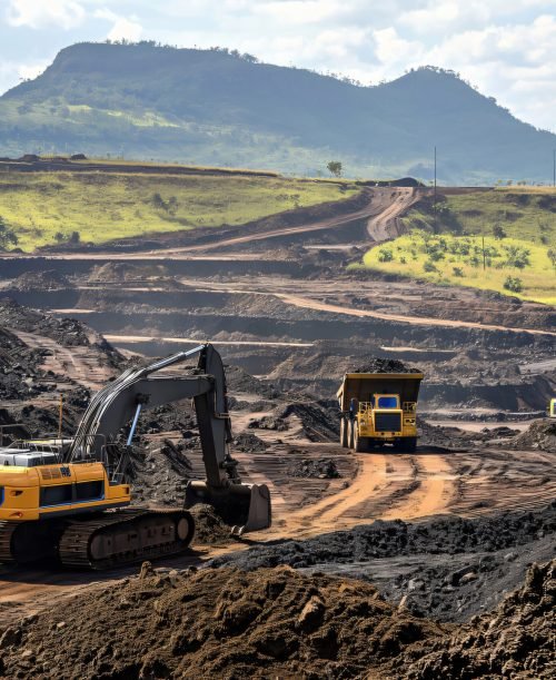 Excavators and dump trucks working in a coal mine in Mozambique, Africa. Mining machinery extracting resources, impacting the environment